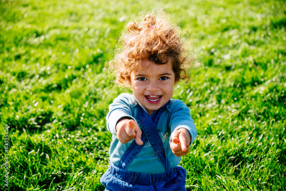 Outdoor portrait of cute little girl smiling in park. Happy child playing in park. Outdoor portrait of cute little girl smiling in park. Happy child playing in park.