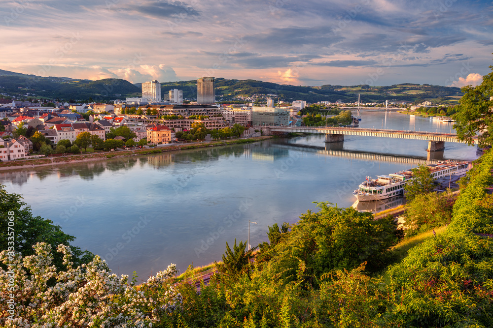 Linz, Austria. Aerial cityscape image of riverside Linz, Austria during spring sunset with reflection of the city in Danube river.