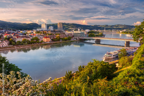 Linz  Austria. Aerial cityscape image of riverside Linz  Austria during spring sunset with reflection of the city in Danube river.