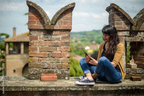 Young woman enjoying scenic view while using smartphone photo