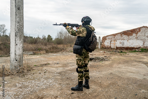 Russian special forces soldier holds a Kalashnikov assault rifle in his hands and stands in sight. Russian assault military forces soldiers at combat action. military exercises in the Russia army. photo