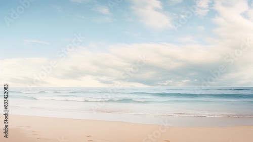 A serene beach scene with gentle waves  a blue sky filled with clouds  and footprints in the sand.