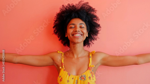 Joyful woman in yellow dress with arms outstretched
