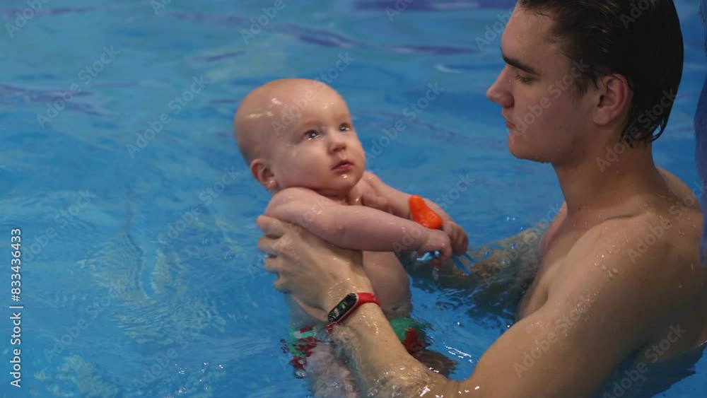 Swim coach teach a baby to dive under water. Newborn baby diving under water. 4K Swim coach teach a baby to dive under water. Newborn baby diving under water. 4K