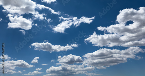 Fluffy cumulus clouds on blue sky background. Cloudscape
