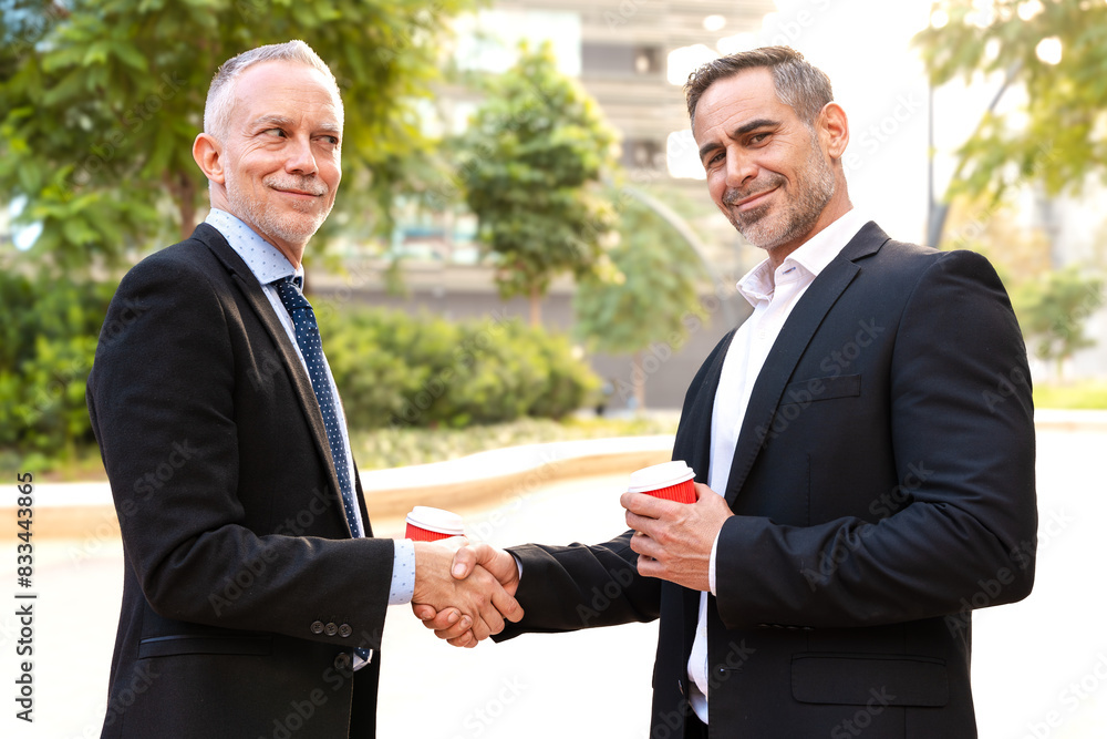 Two colleagues face each other, high-five, look at the camera, work as a team, ready to start a new project, pose outdoors Two colleagues face each other, high-five, look at the camera, work as a team, ready to start a new project, pose outdoors