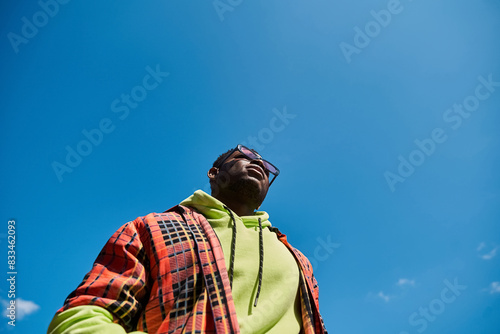 Handsome African American man in stylish jacket looks up at the sky. © LIGHTFIELD STUDIOS