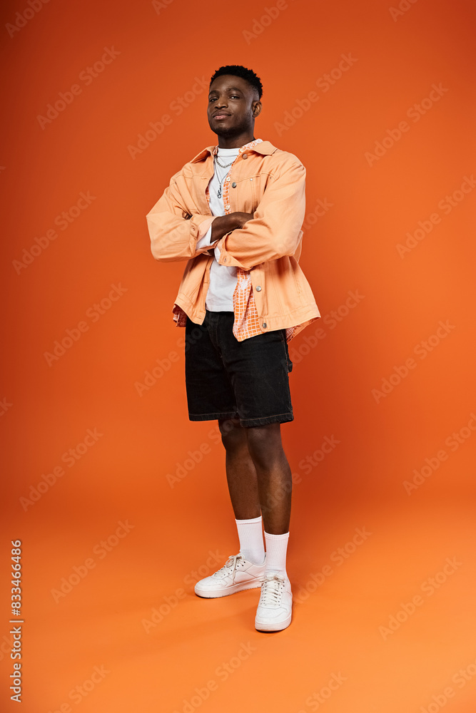 Fashionable man in orange attire against matching background. Fashionable man in orange attire against matching background.