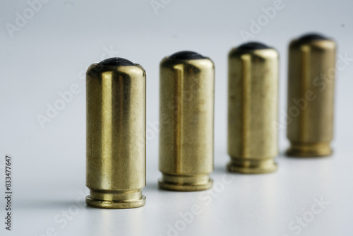 Array of brass bullet shells lined up neatly on a plain white surface