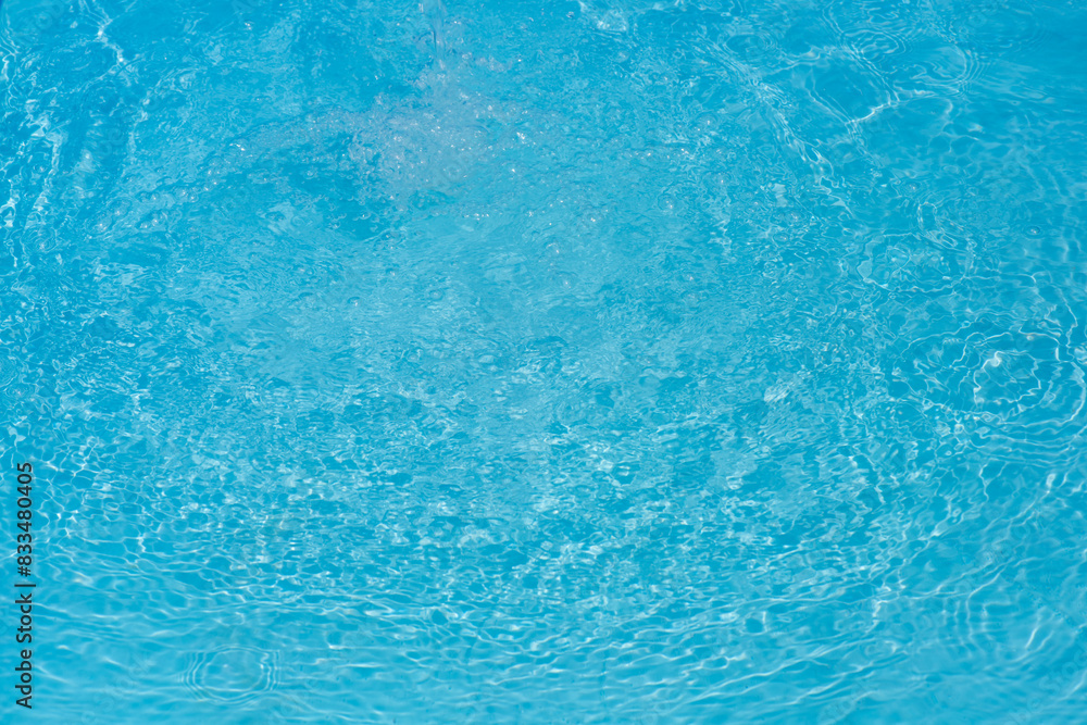 Blue water with ripples on the surface. Defocus blurred transparent blue colored clear calm water surface texture with splashes and bubbles. Water waves with shining pattern texture background. Blue water with ripples on the surface. Defocus blurred transparent blue colored clear calm water surface texture with splashes and bubbles. Water waves with shining pattern texture background.