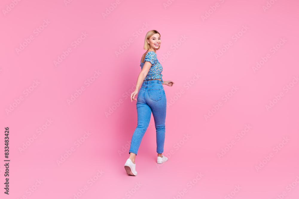Full body rear portrait of nice young lady walk empty space wear top isolated on pink color background Full body rear portrait of nice young lady walk empty space wear top isolated on pink color background