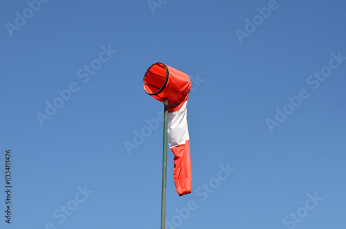 White and red striped wind sock. Strong wind and bad weather symbol. Climate Change. Weather forecast. Storm is coming. photo