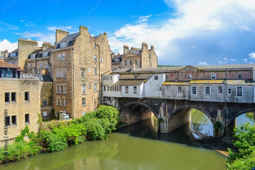 Fototapeta premium UK, Bath, 26.05.2024: Pulteney weir and a view of the Pulteney bridge, an ohn of 4 bridges in Europe with buildings on it