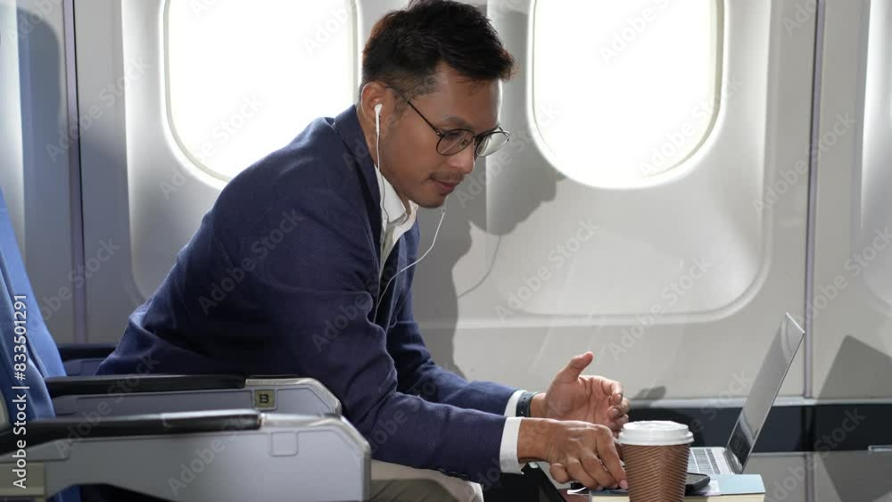 Traveling and technology. young businessman working on laptop computer and smartphone while sitting in airplane. Traveling and technology. young businessman working on laptop computer and smartphone while sitting in airplane.