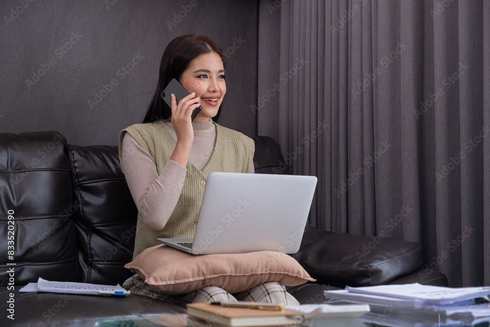 Woman Using Laptop and Smartphone on Sofa. Concept of multitasking and modern lifestyle. Woman Using Laptop and Smartphone on Sofa. Concept of multitasking and modern lifestyle.