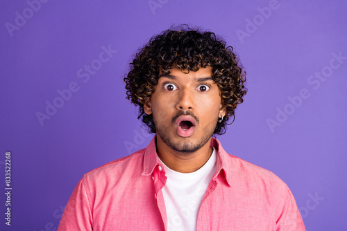 Photo of nice young man open mouth stare wear pink shirt isolated on violet color background