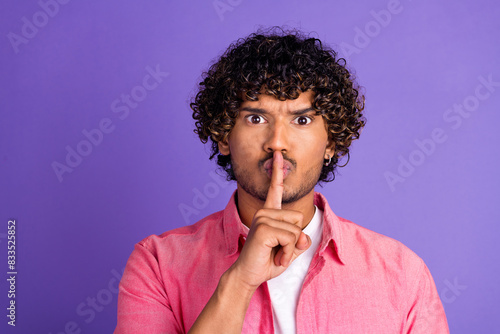 Photo of nice young man show shush gesture wear pink shirt isolated on violet color background