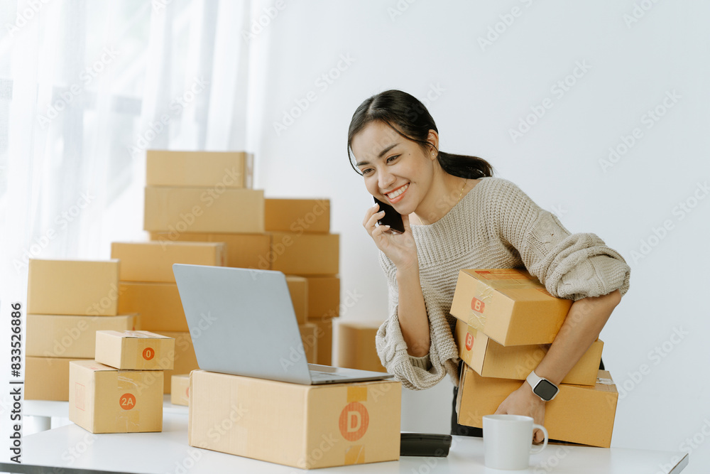 Starting small businesses SME owners asian female entrepreneurs call phone on receipt box and check online orders to prepare to pack the boxes, sell to Starting small businesses SME owners asian female entrepreneurs call phone on receipt box and check online orders to prepare to pack the boxes, sell to