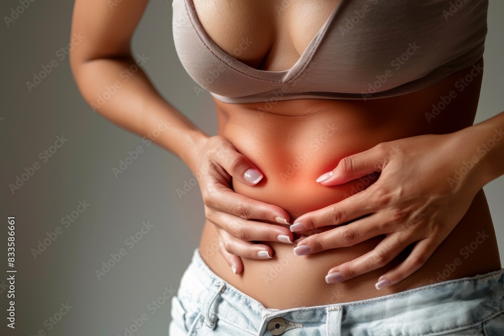 Close-up of woman experiencing abdominal pain. Female holding her stomach, indicating discomfort or cramps. Health and wellness concept. Close-up of woman experiencing abdominal pain. Female holding her stomach, indicating discomfort or cramps. Health and wellness concept.