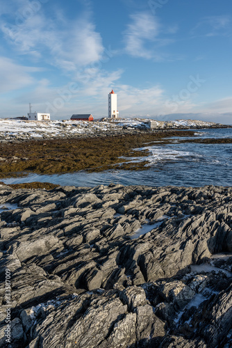 A Lighthouse on the rugged coast of the Barents Sea on a sunny winter day, Berlevåg Norway photo