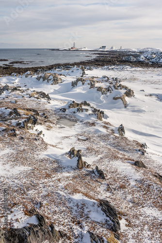 A Lighthouse on the rugged coast of the Barents Sea on a sunny winter day, Berlevåg Norway photo