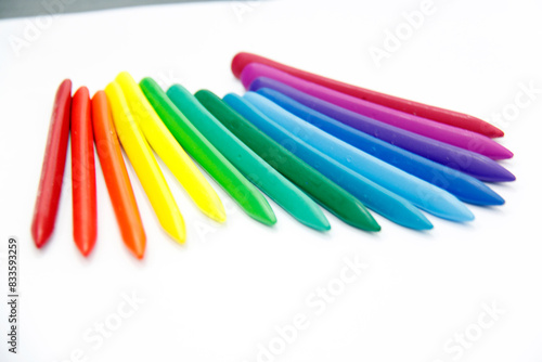 Triangular colored crayons on a white background