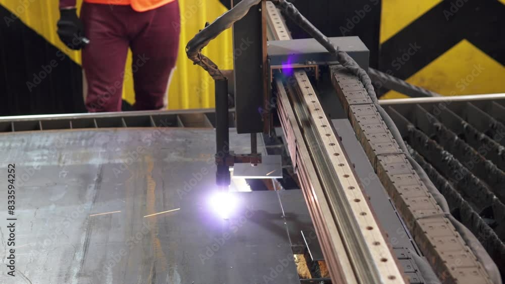 Plasma cutting of metal on a CNC machine. Industrial cutting of metal with a plasma laser at a metallurgical plant. Sparks fly from melting metal. Making metal parts using a computer program.