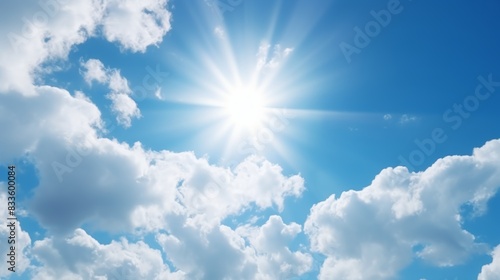 Sun with rays and glare clear blue sky and clouds Sunshine in a blue sky with white cumulus clouds in bright weather