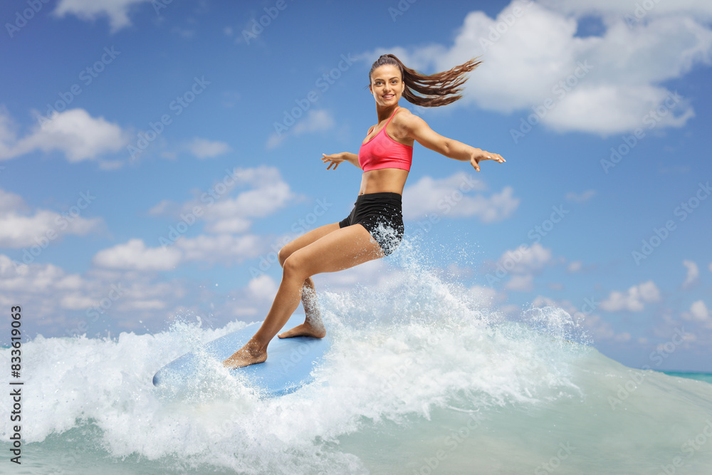 Female surfer riding a surfboard on a wave Female surfer riding a surfboard on a wave