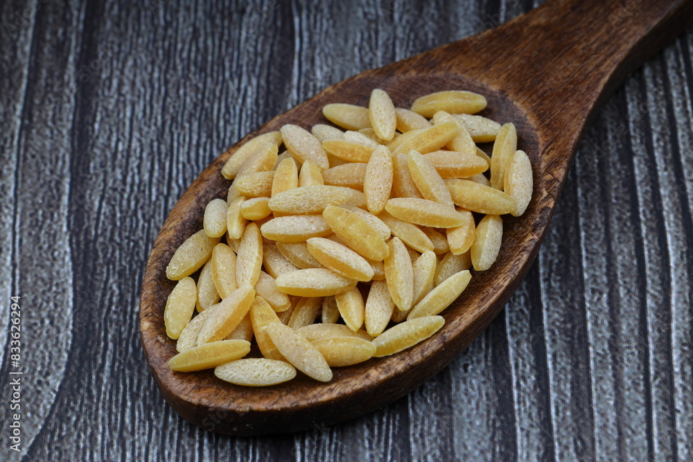Raw fresh and healthy dry organic barley noodle on wooden spoon Raw fresh and healthy dry organic barley noodle on wooden spoon