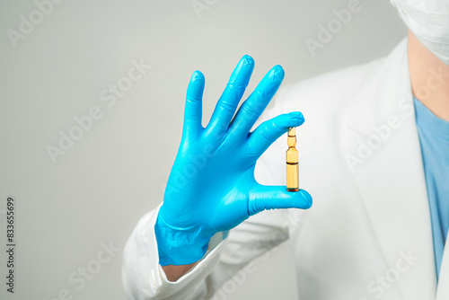 doctor or scientist holding ampules medicine vaccine and bottle for injection