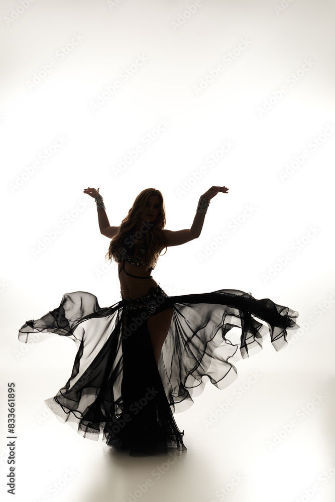 A mesmerizing woman in a black dress gracefully dances. A mesmerizing woman in a black dress gracefully dances.