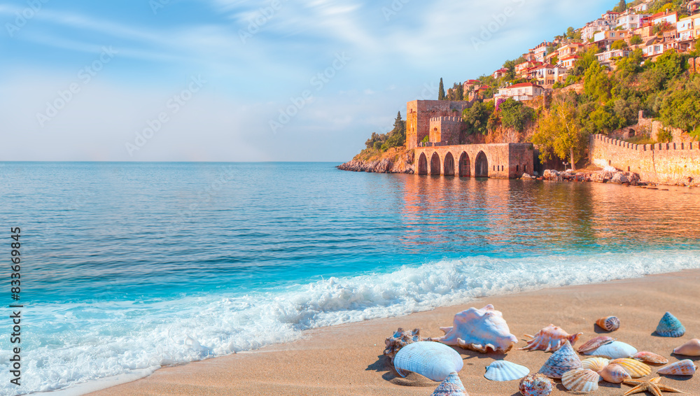 Fototapeta premium Beautiful sandy beach and soft turqoise Mediterranean sea wave - Landscape of ancient shipyard near of Kizil Kule tower - Alanya peninsula, Turkey