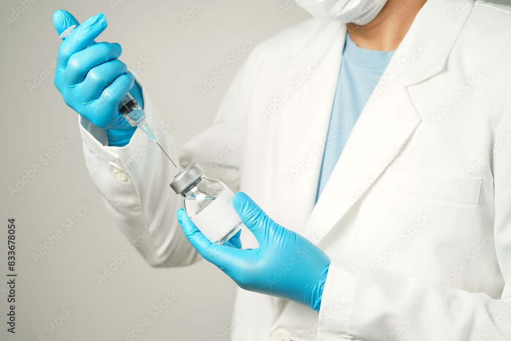 Fototapeta premium doctor or scientist holding a syringe with ampules vaccine, bottle for injection