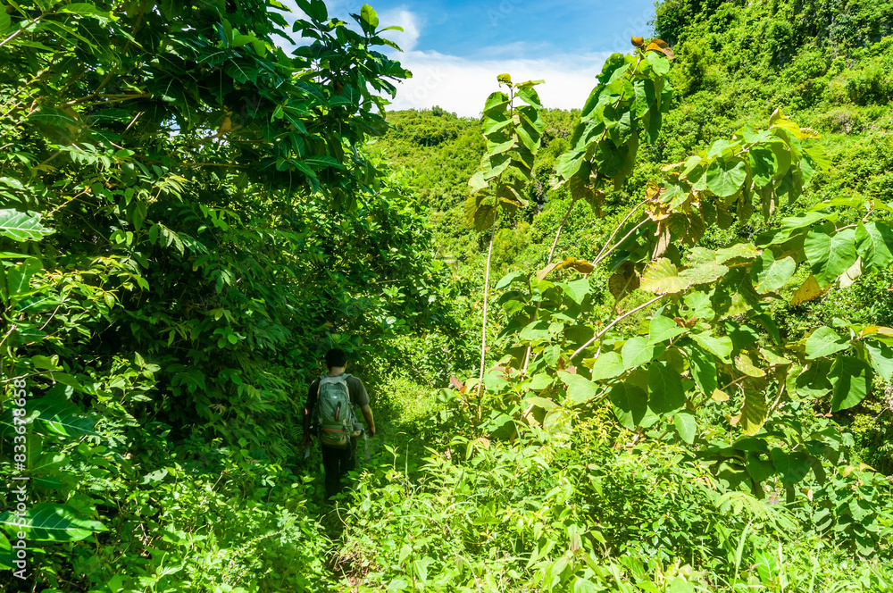 Gunungkidul, Indonesia - December 26, 2016. Asian man walks exploring towards Ngelangkap beach during the day.