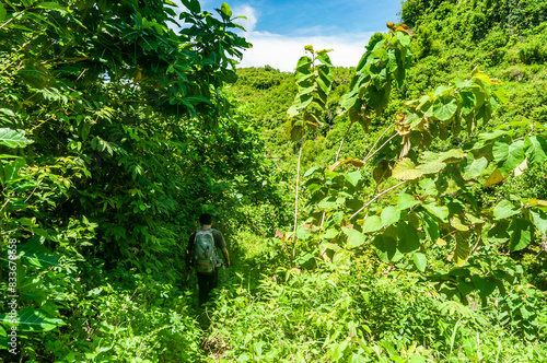 Obraz na płótnie Gunungkidul, Indonesia - December 26, 2016. Asian man walks exploring towards Ngelangkap beach during the day. w salonie