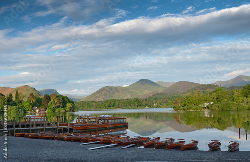 Keswick rowing boats and launches on a calm Derwentwater. Causey Peak is the dark summit behind.