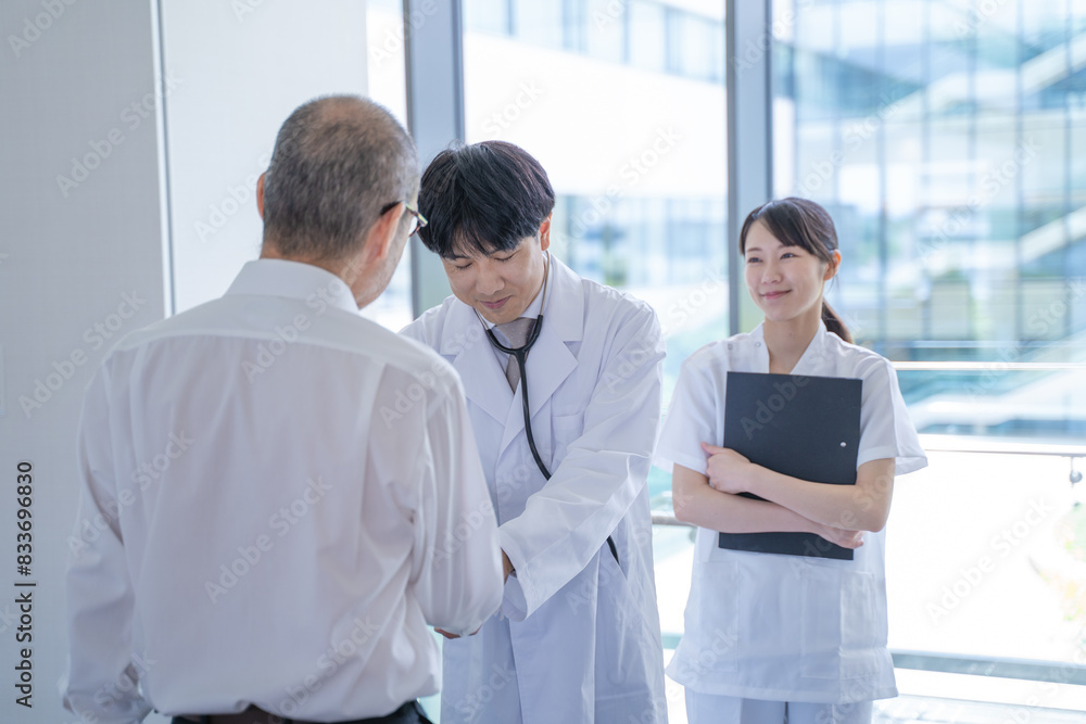 握手する男性医師と看護師と患者 握手する男性医師と看護師と患者