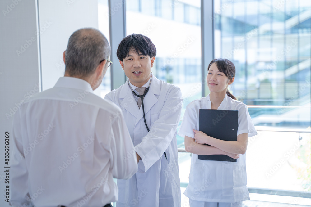 握手する男性医師と看護師と患者 握手する男性医師と看護師と患者