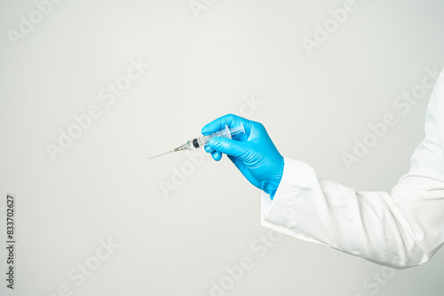 doctor or scientist holding a syringe in blue gloves