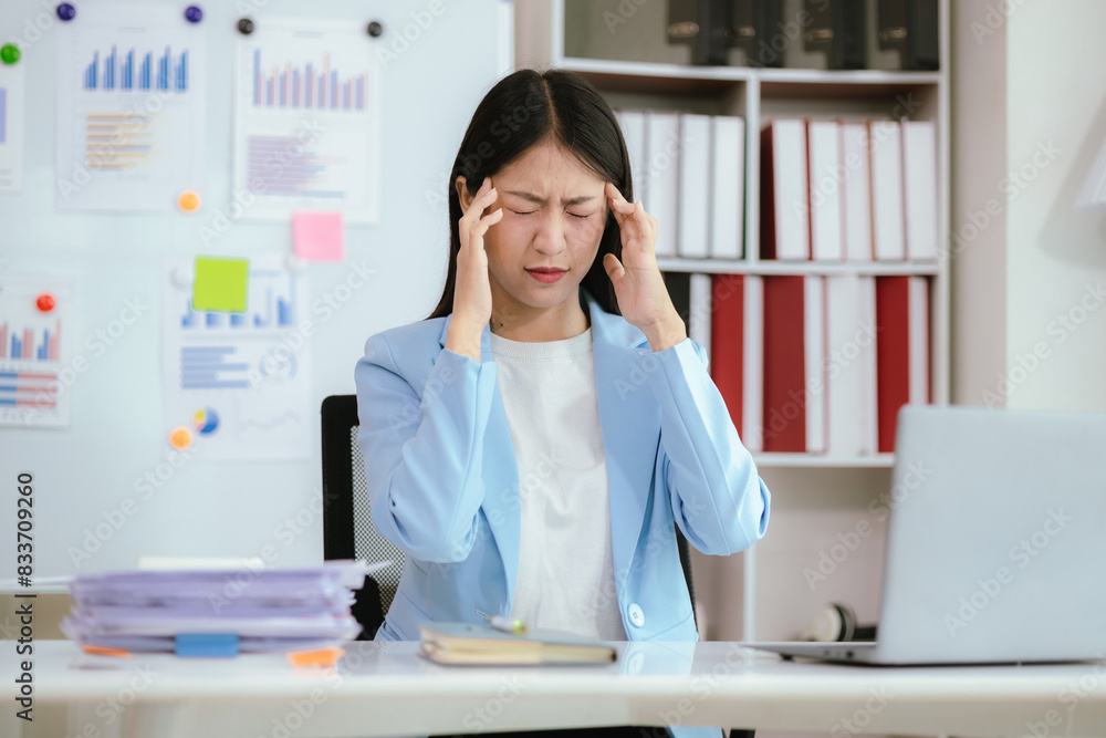 Asian businesswoman who is suffering from headache and stress due to overwork. Asian businesswoman who is suffering from headache and stress due to overwork.