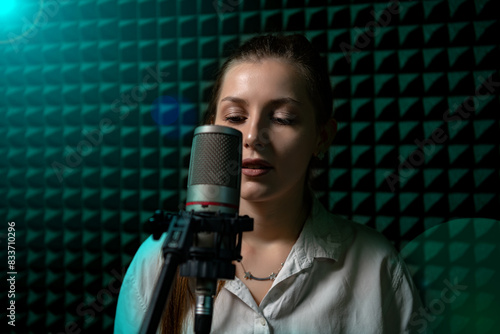 Cute girl in recording studio with mic over acoustic absorber panel background