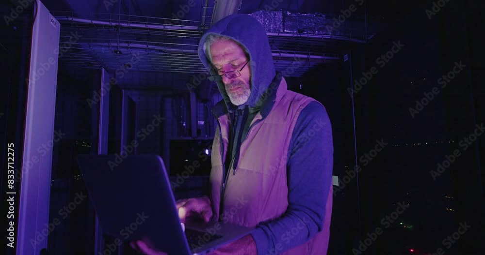 Man in Hoodie Accessing Server Room at Night Man in Hoodie Accessing Server Room at Night