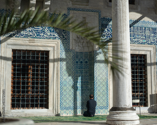A person prays in the decorated niche of the Eminönü Mosque in Istanbul