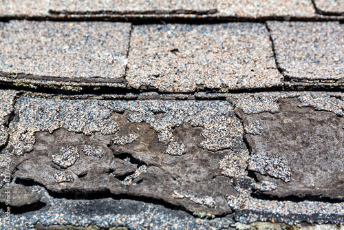 Close view of a row of weathered shingles damaged from the sun.
