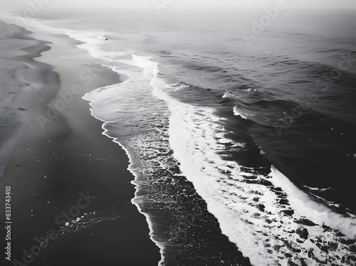 wave breaking on the beach black and white 