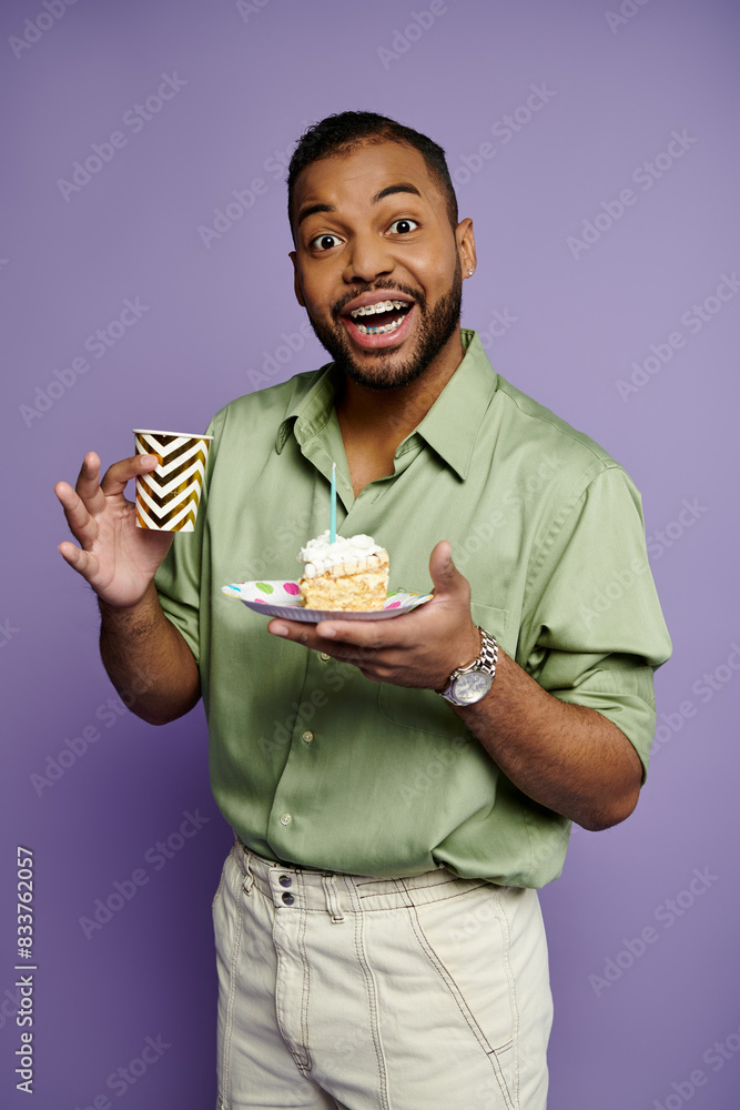 Young African American man with braces smiling while holding a plate with a delicious piece of cake. Young African American man with braces smiling while holding a plate with a delicious piece of cake.