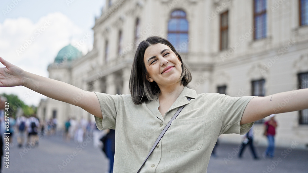 Young beautiful hispanic woman with open arms at Belvedere Palace in Vienna