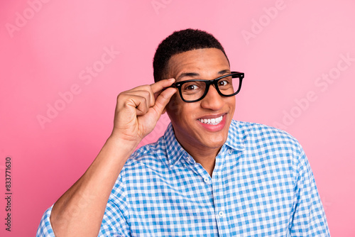 Photo of attractive funny guy wear plaid shirt arm spectacles emtpy space isolated pink color background