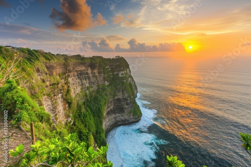 Cliffside view of the ocean with a dramatic sunset background photo